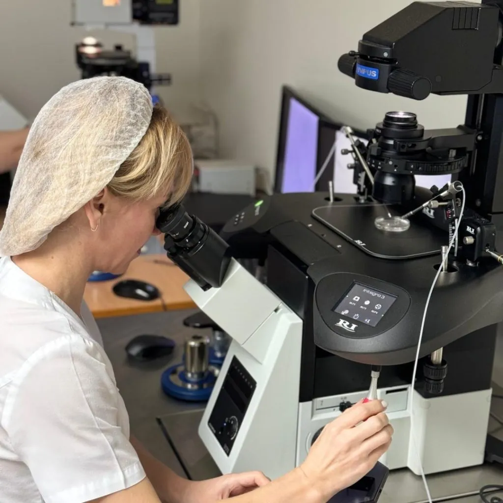 Aphrodite Egg Bank embryologist working at a laboratory microscope