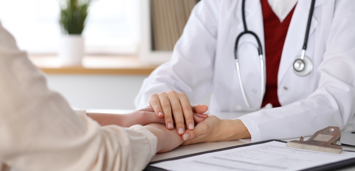 Doctor holding a donors hands in a reassuring manner